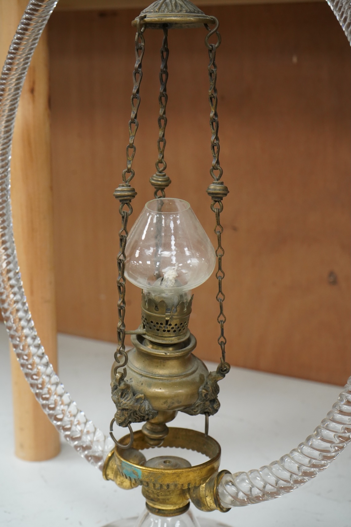 A Victorian glass frame with a central brass hanging oil lamp. 48cm high